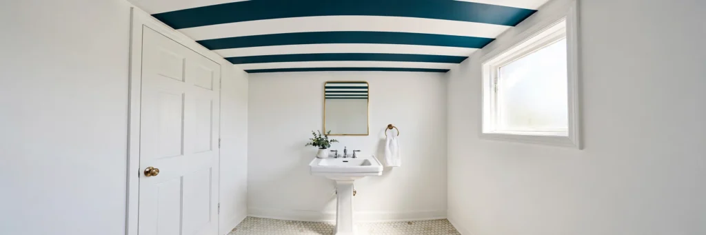 Small white powder room with a bold striped ceiling and plain white walls.