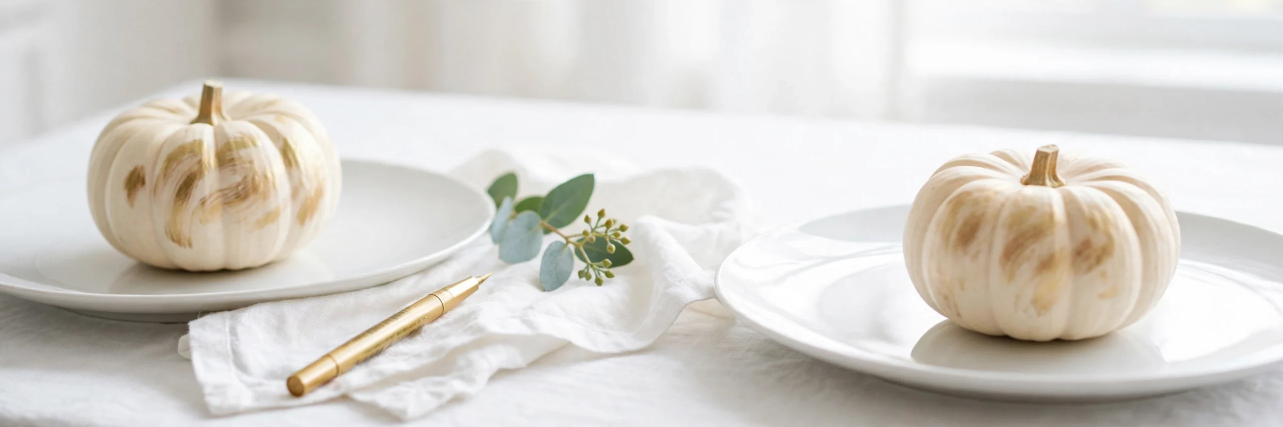 mini pumpkin place cards on white plates with a gold pen